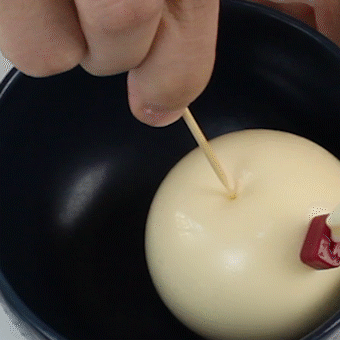 浑圆的奶酪布丁装在气球外衣里,要用牙签轻轻戳破后才能生出一个