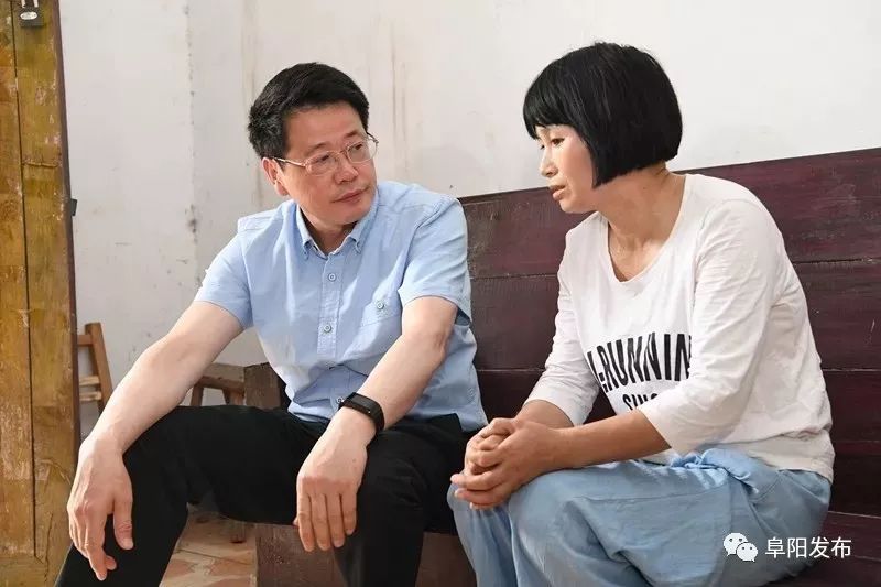 在临泉县长官镇长官居委会贫困户张丽家中,杨光荣与她亲切交谈,详细