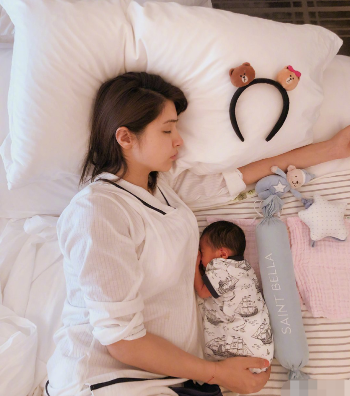 姜潮麦迪娜与儿子合照小家伙躺妈妈怀里熟睡头发浓密十分可爱