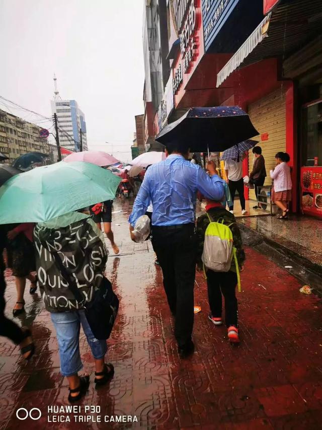 實驗小學門口上演,這位父親不顧大雨淋溼衣服,只為安全把孩子送進校園