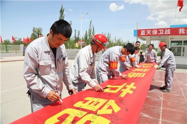 新疆富丽达干部员工在节能减排横幅上签字(李明杰 摄)