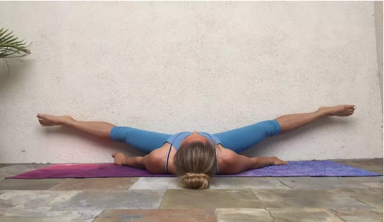 保持5-8个呼吸十,抵墙坐角式坐立在墙壁的前方,面对墙壁双脚打开抵住