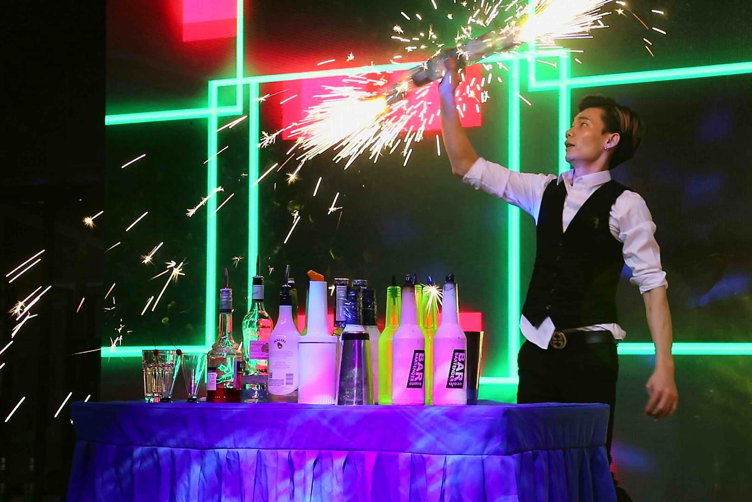 璀璨的焰火中,花式调酒师阿兽正在十分专注开心地进行他的表演.