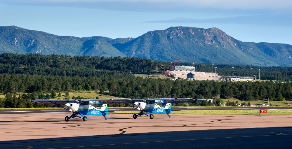 两架停在跑道上的飞机. 飞行学院的学员和滑翔机拍照.