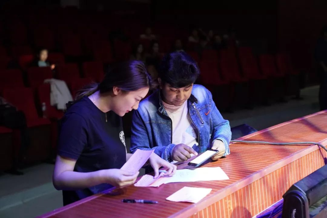 主持人马月明和叶城舞蹈团的老师核对新节目介绍又到一个新的场地了