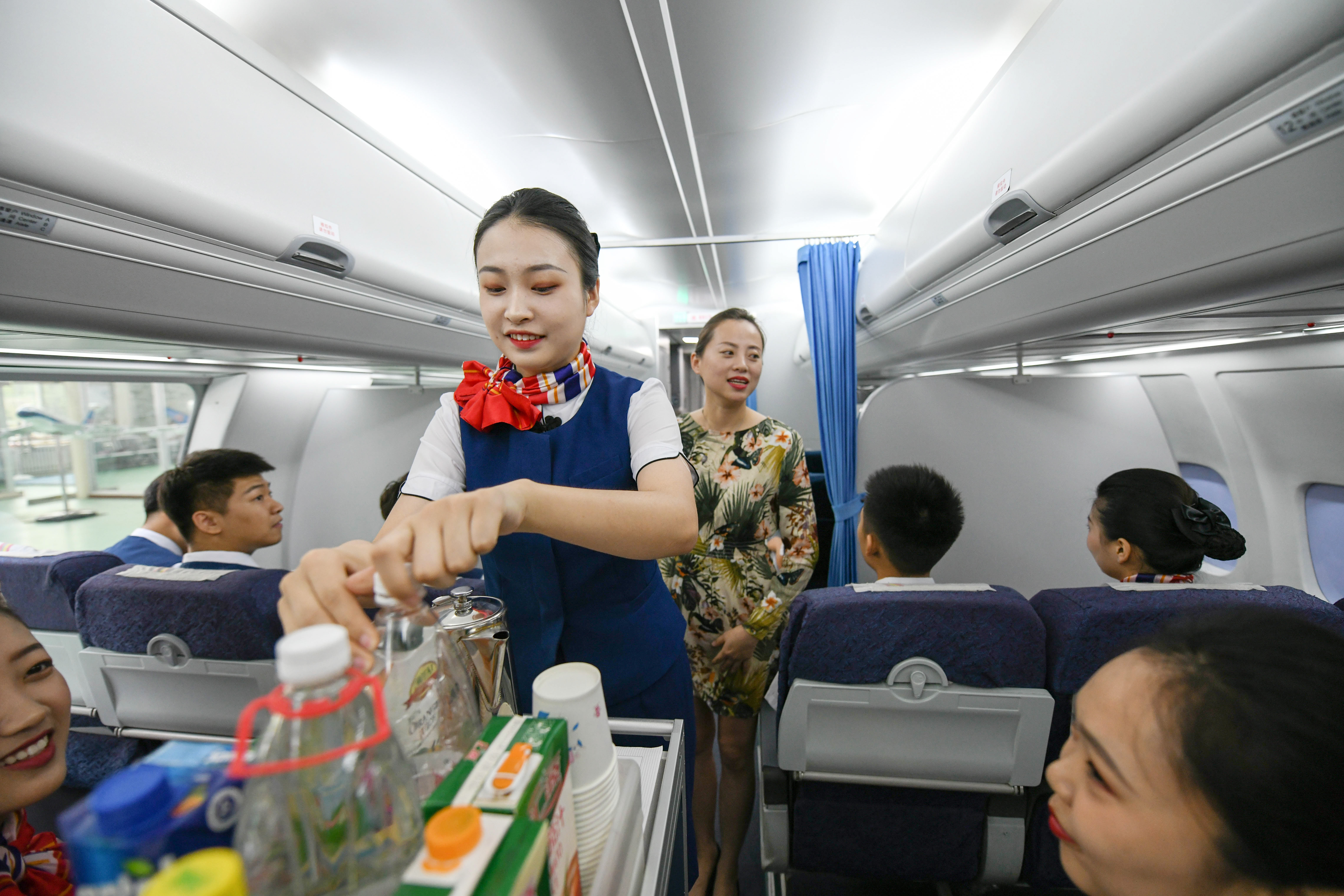 6月27日,空中乘务专业的一名学生(前)在进行模拟机舱服务实训课程