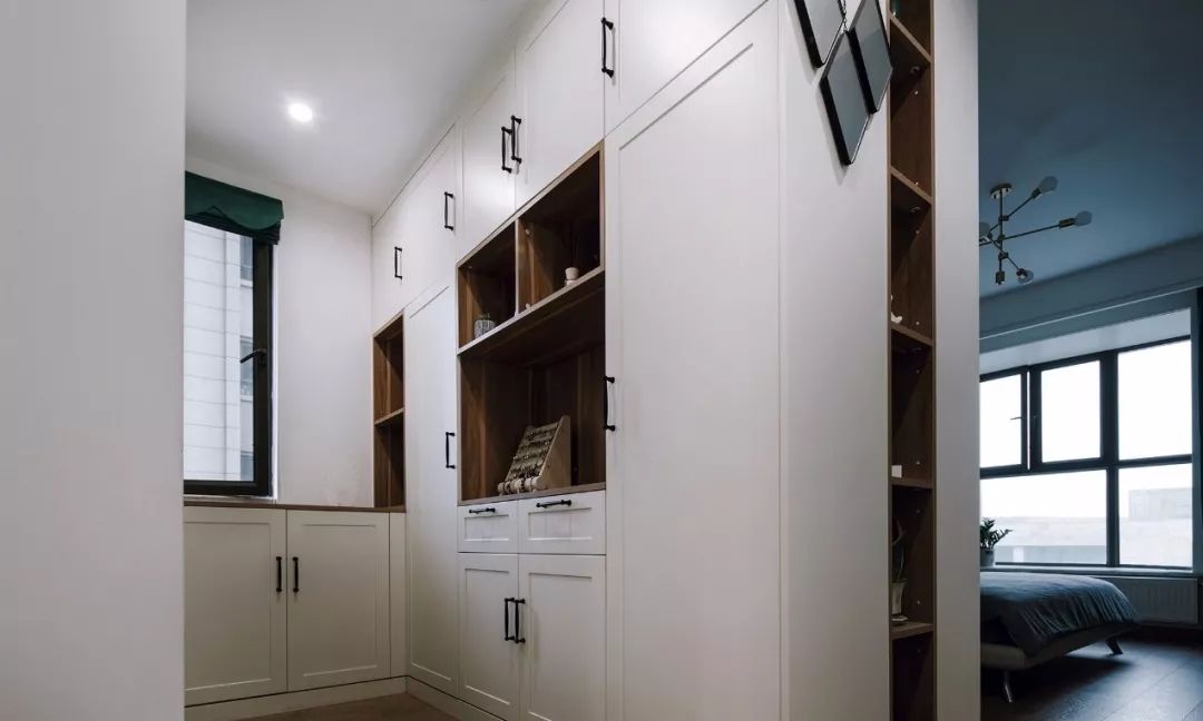 衣柜跟衣帽间的衣柜是背靠背的设计,同时在拐角处做一些装饰隔断