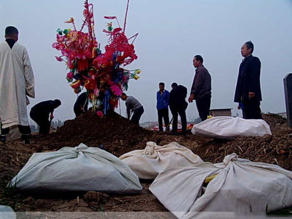 这时我们开始哭着圆坟,就是围着新坟正转三圈,倒转三圈.