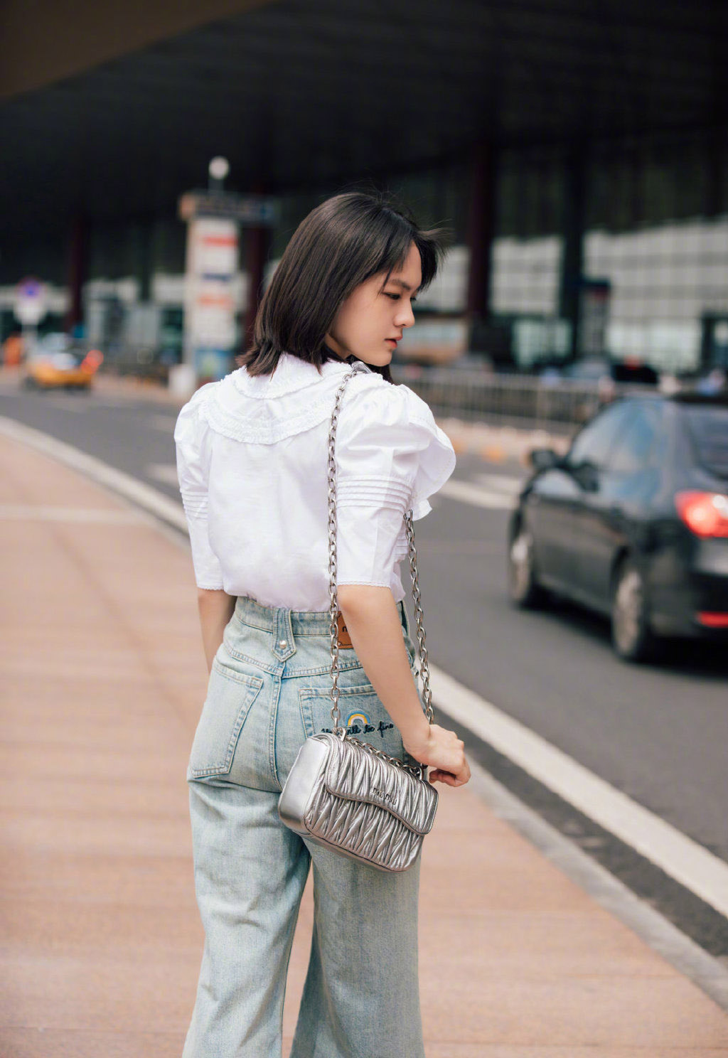 文淇身着白色荷叶边上衣,搭配磨边阔腿牛仔裤和白色宝石凉鞋,清新灵动