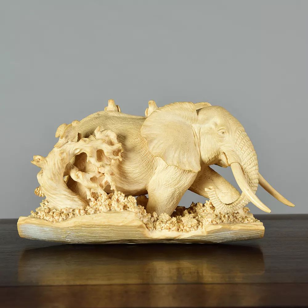 大象此作以猛犸牙为材,童子以圆雕技法雕刻,再于头发,服饰等处施彩料