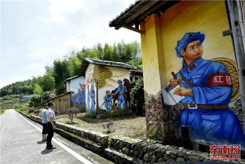 图为游客在新桥乡岭下村的红军壁画前缅怀革命先烈.