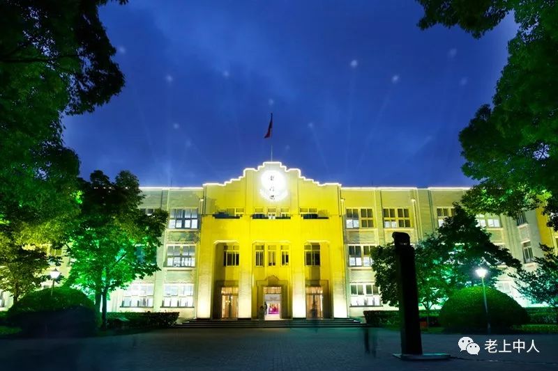 此时,龙门楼外亮起了炫彩灯光,龙门楼背面的墙上投射出上海中学校徽.