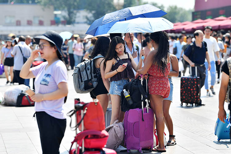 北京站,外国旅客打伞遮阳.