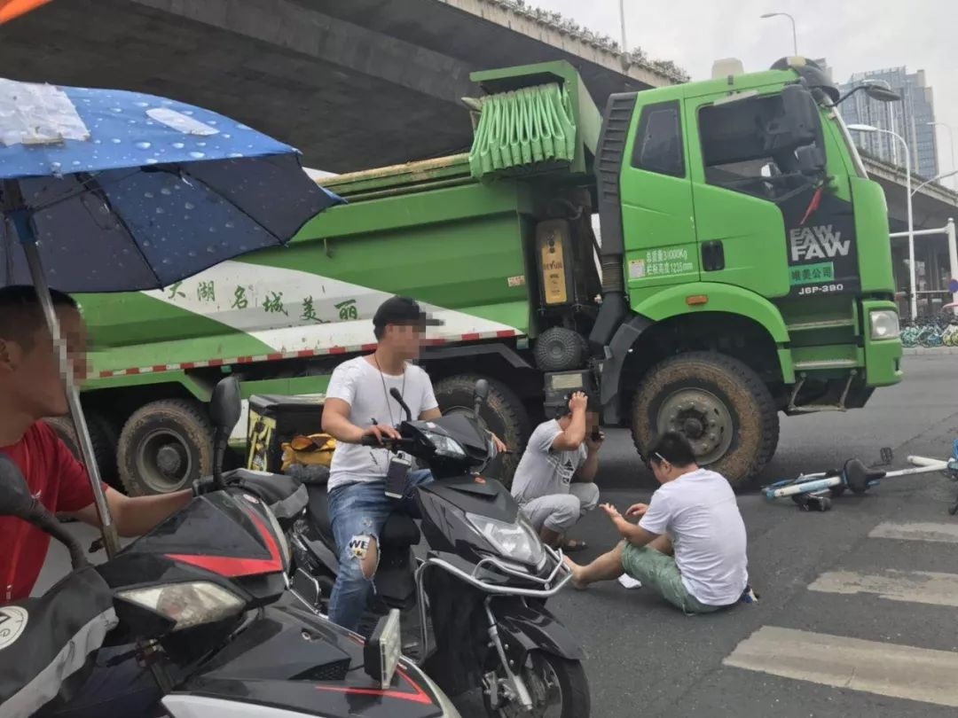 視頻顯示,事發時,一輛單車倒在該路口,一旁還停著多輛皖a牌照的渣土車