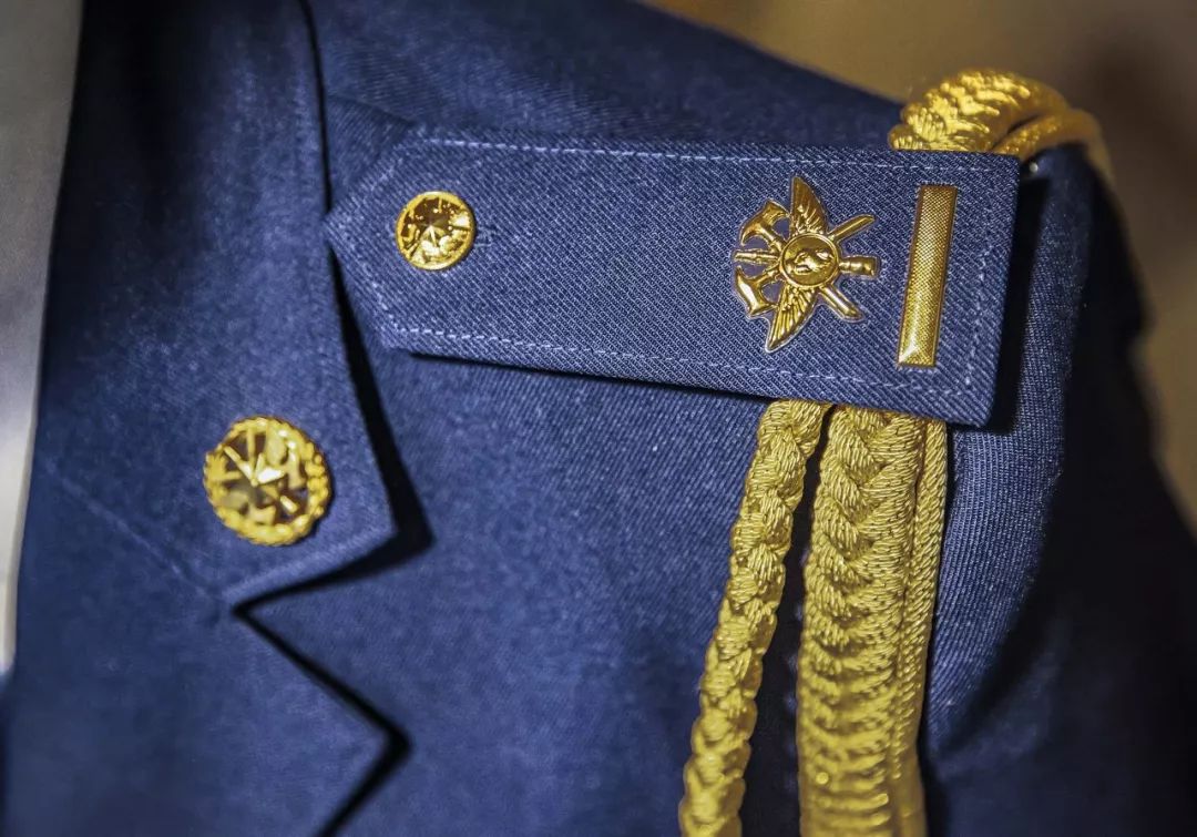 领花//镶嵌五个五角星徽标上端底色为红色主色调为银白色整体造型为圆