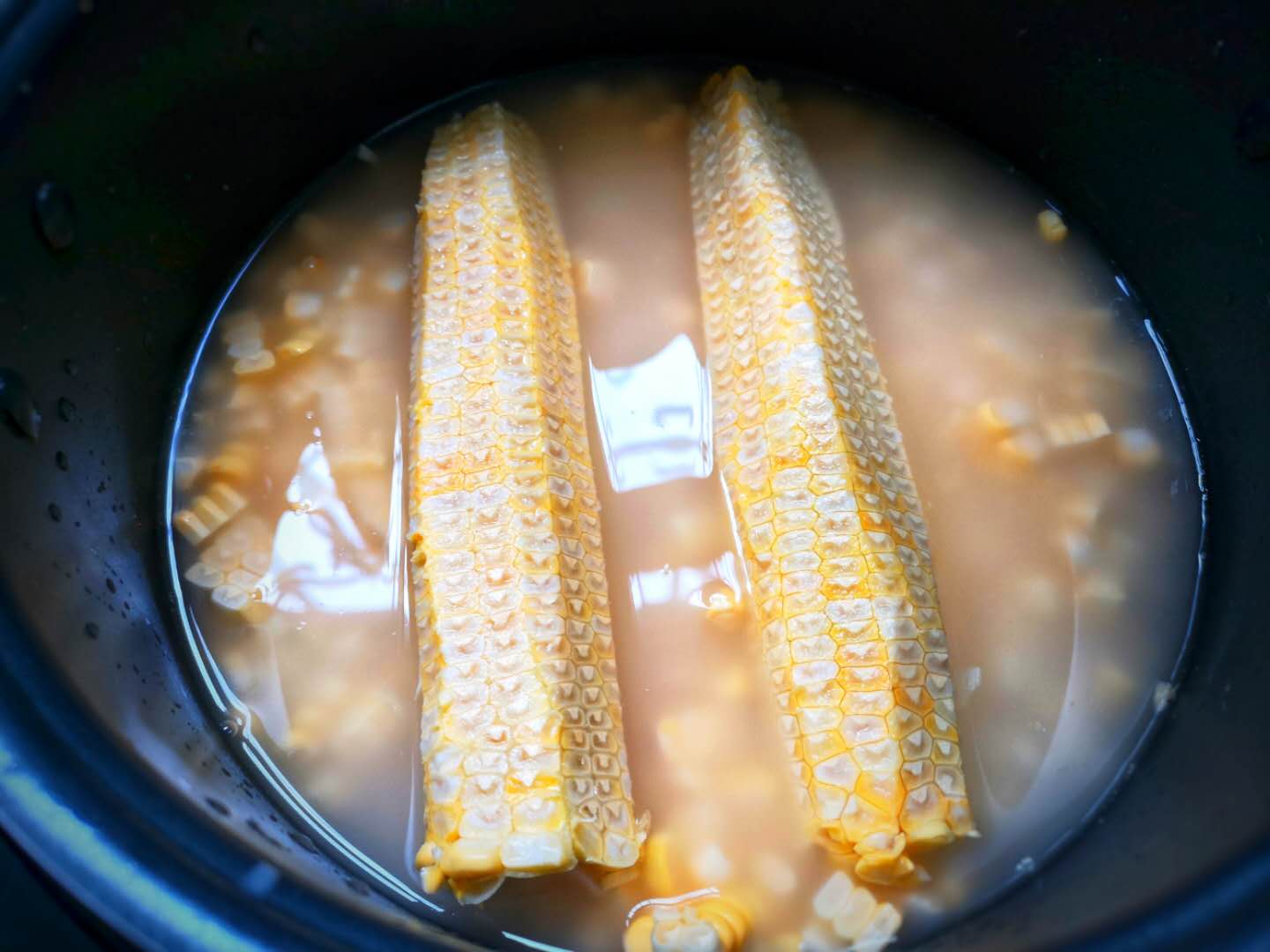 5,然后把玉米芯也放进去.盖上盖子,选择电饭煲蒸饭键.