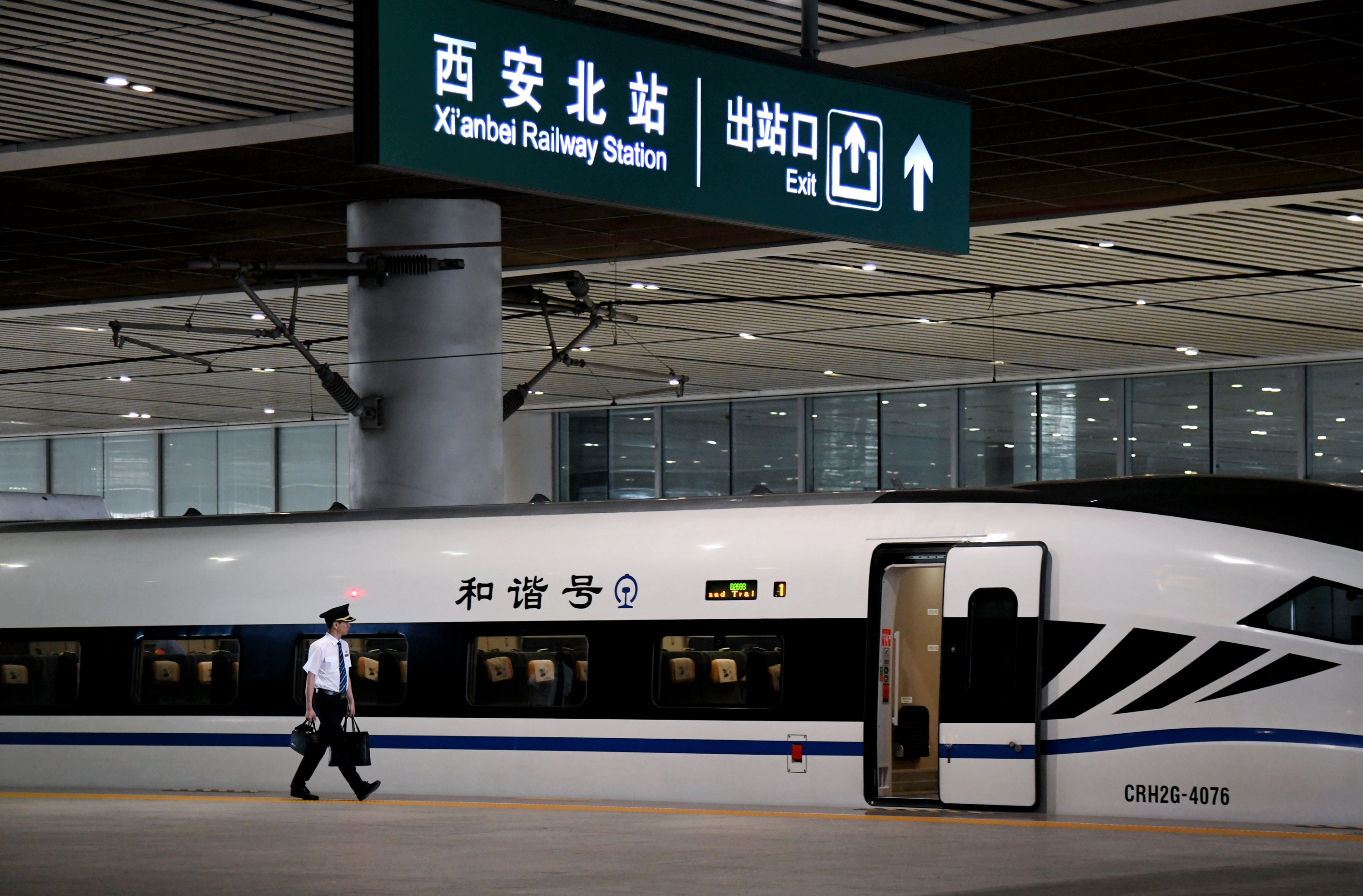 7月10日,铁路工作人员在西安北站准备登上将要发车的动车组列车