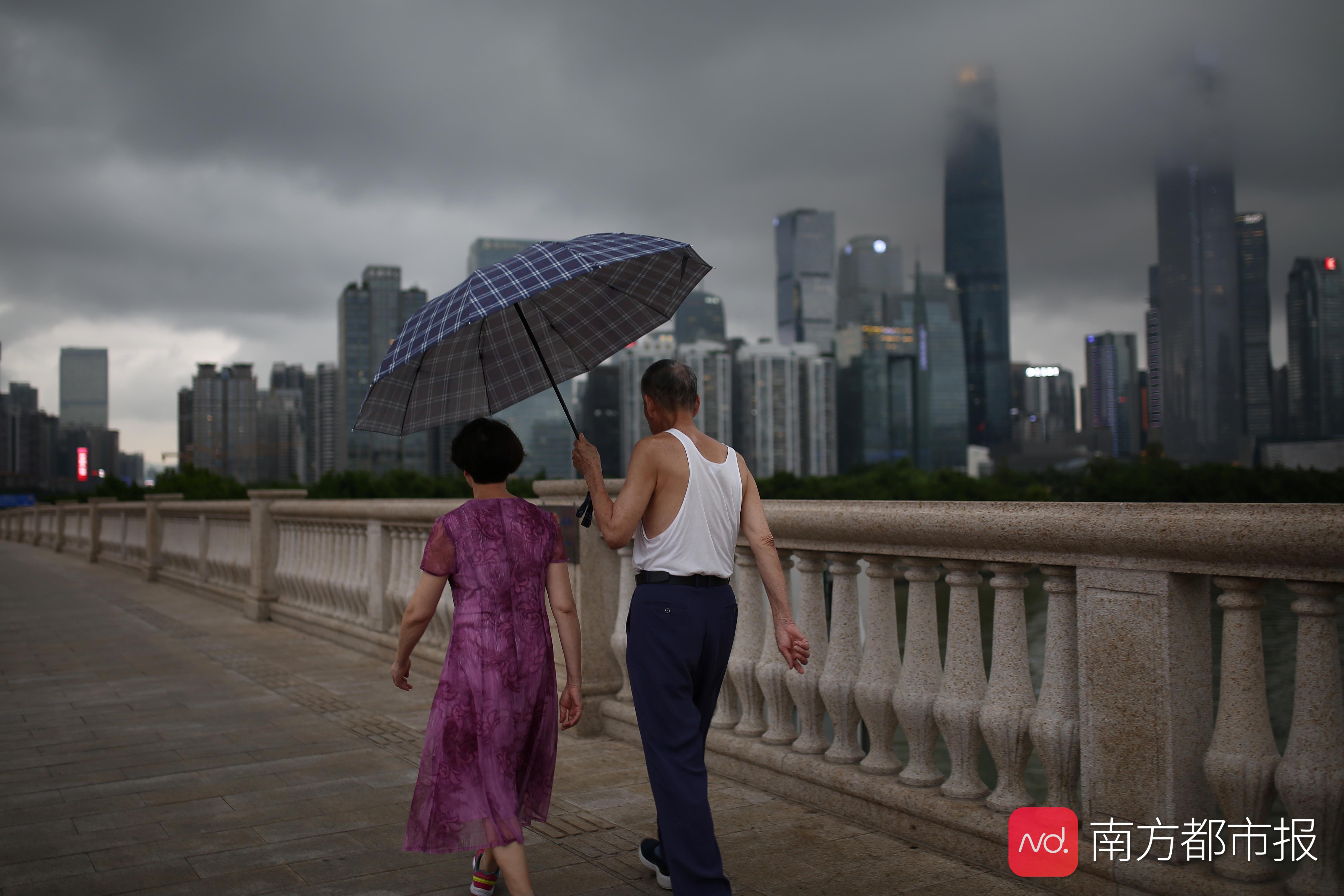 7月10日晚7点,广州大桥,上空乌云密布,雨中一老人为妻子撑伞过桥