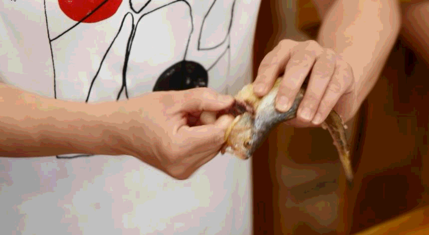 用手指对准鱼鳃部位,勾出鱼鳃,这样可以保持鱼的完