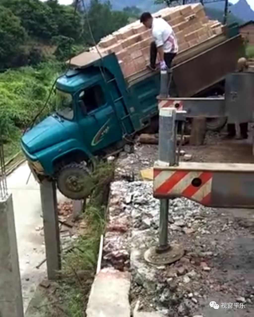 驚險平樂一輛拉磚貨車突然衝出路面半截車身懸掛在水泥樁上