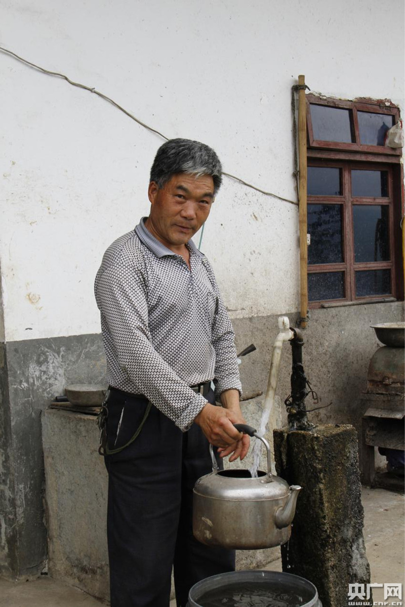 许明松准备为远道来的客人烧水喝.(张兆福 摄)