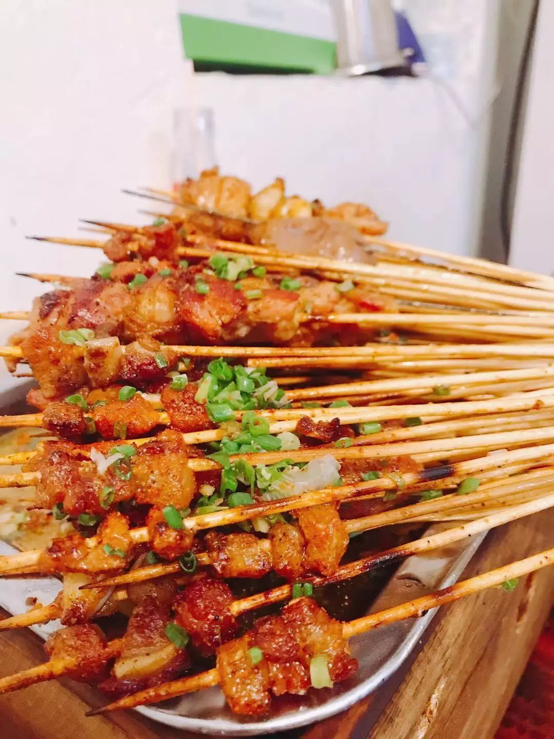 烈火牛肉,将铁板烧热抹油,一把把竹签穿好的牛肉来回蹭熟,快速翻蹭