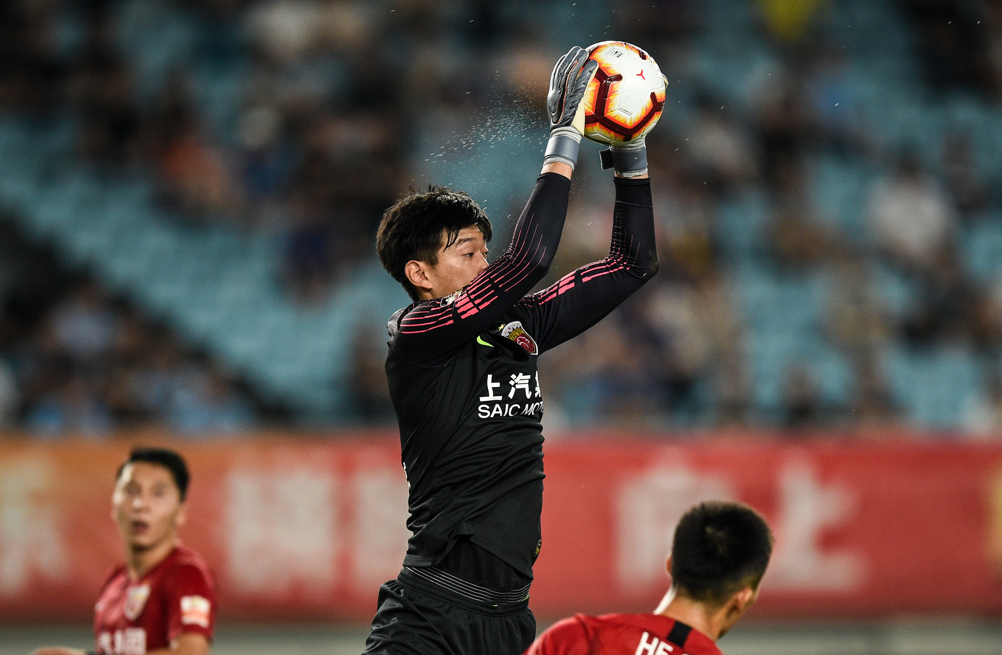 7月13日,上海上港队守门员颜骏凌(中)在比赛中扑救