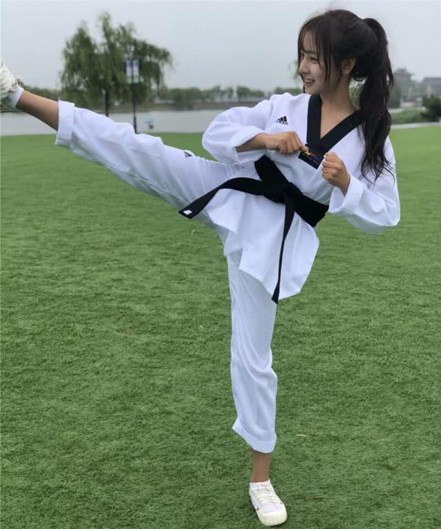 她一头乌黑的马尾,脸庞美丽,穿着一件白色练武功的衣服,间接饰有黑色