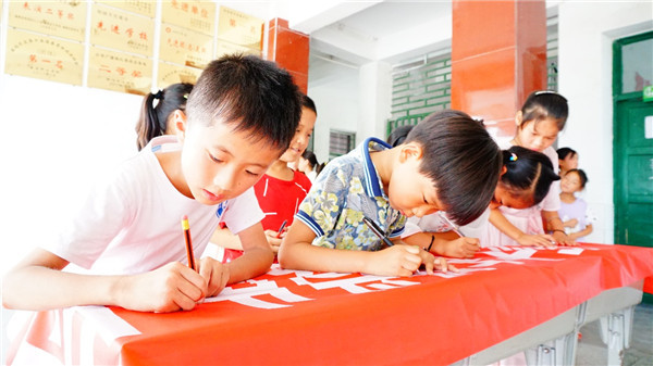 "爸爸妈妈,感谢你们"孩子们在横幅上写下对父母想说的话(汪宇)