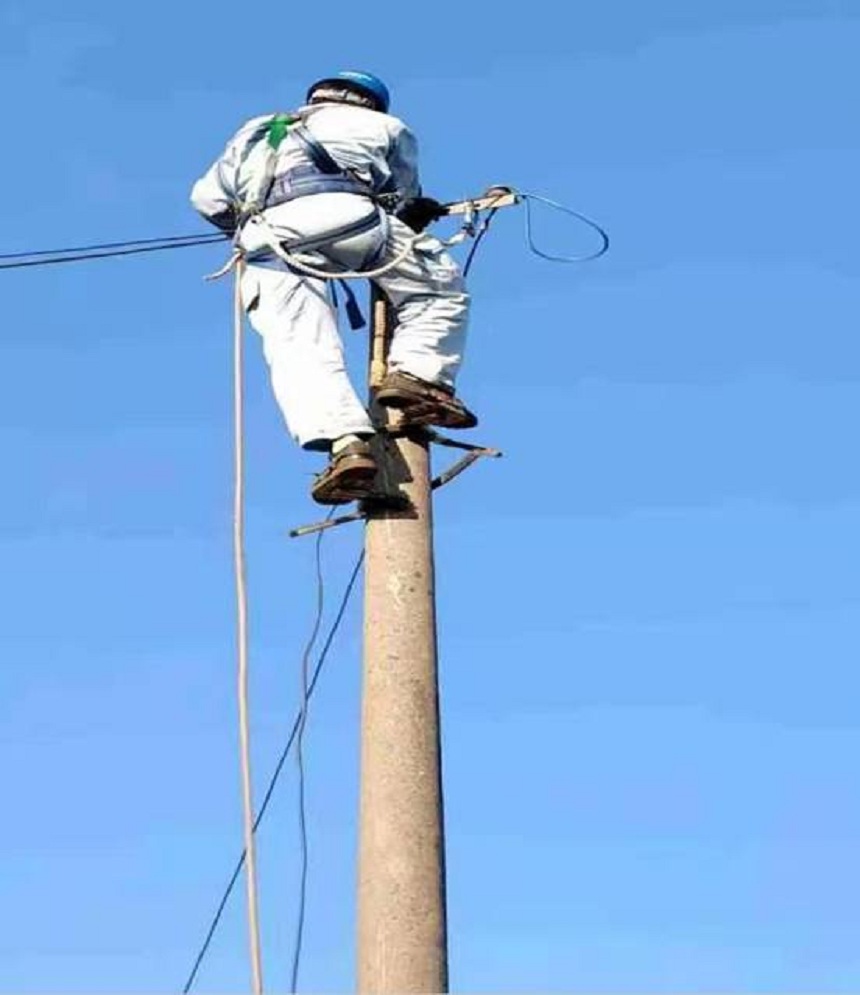 搶修人員登杆作業搶修被車刮斷的電線,保障菸農烤煙用電.