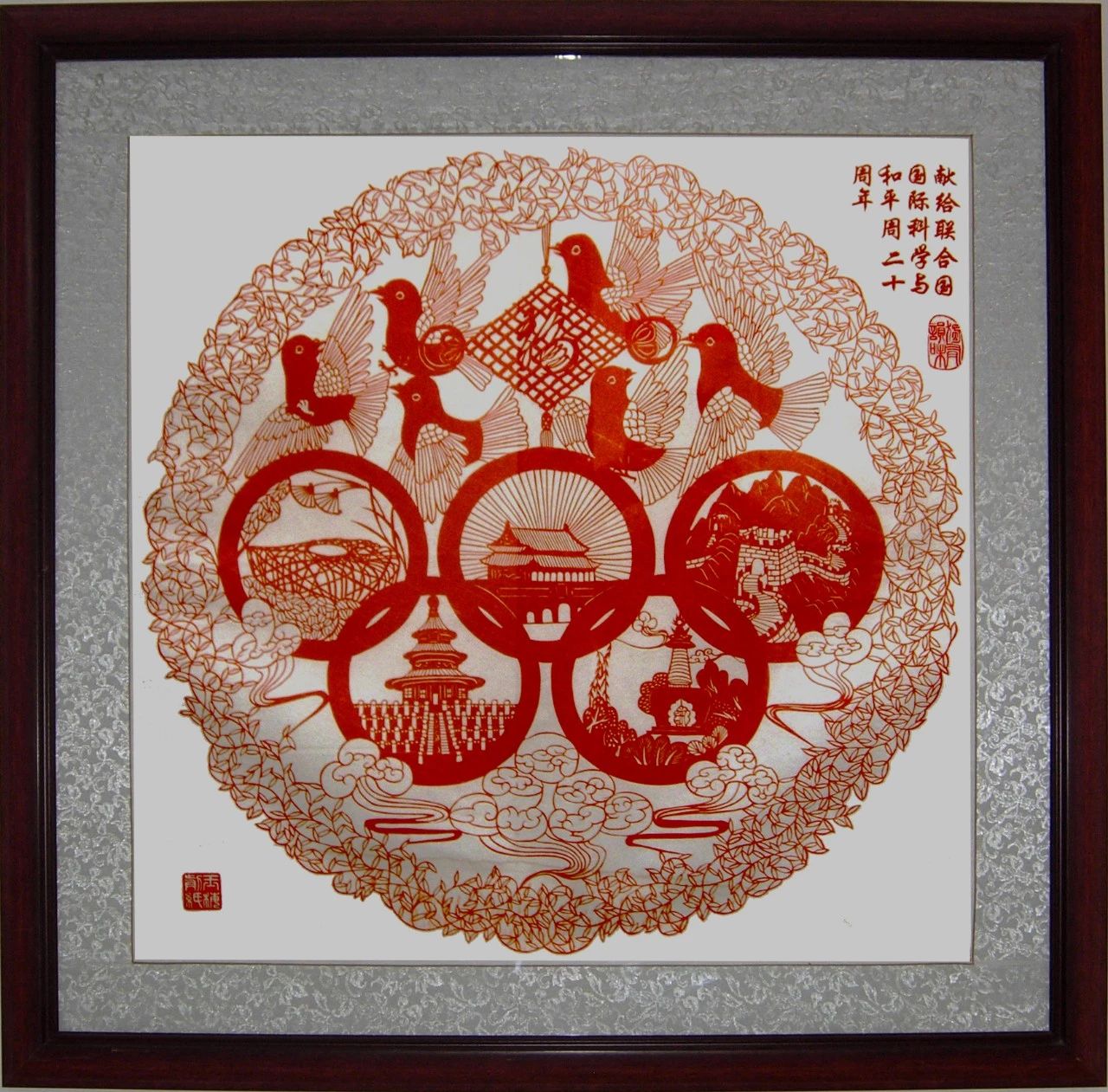 六只可爱的和平鸽环绕在一个鲜红的中国结周围,下方是奥运五环标志,每