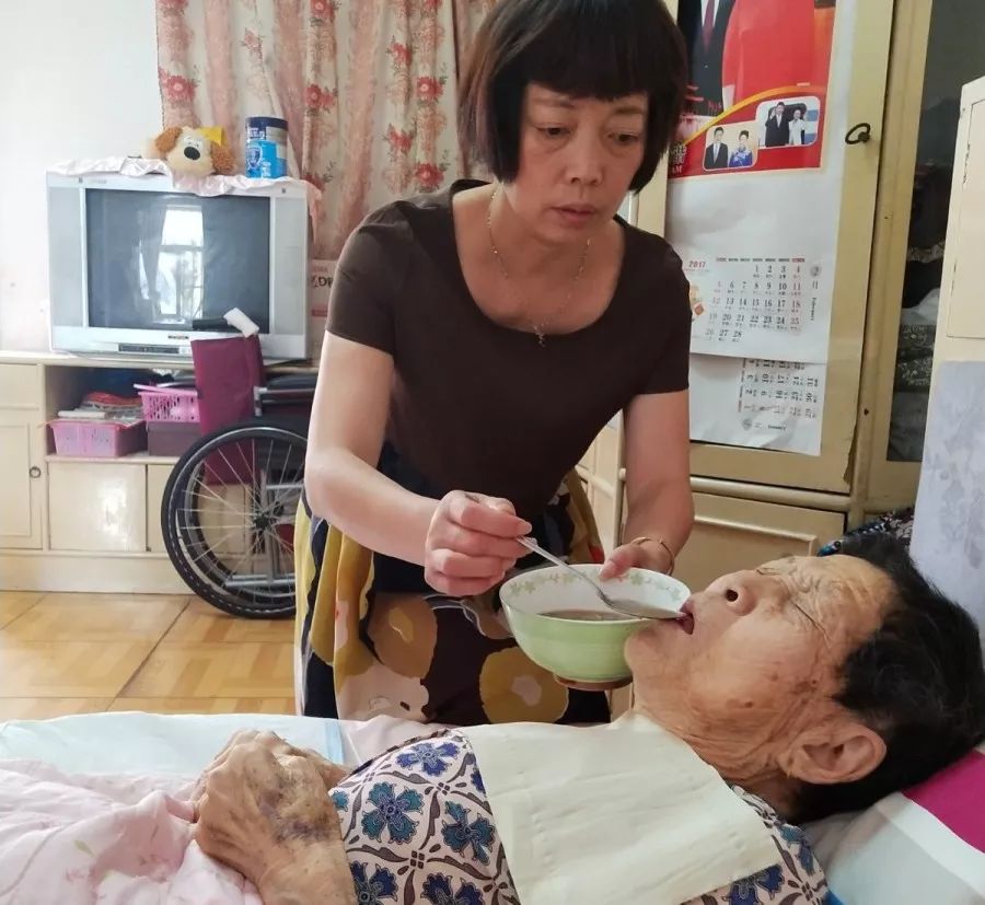 她用一根带子把婆婆绑在自己身上为了帮老人起夜上厕所瘦弱的李小菊抱