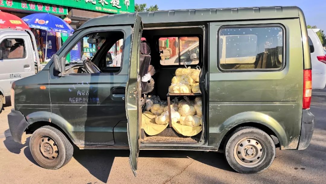 一面包车把馒头放在车座上下送货!