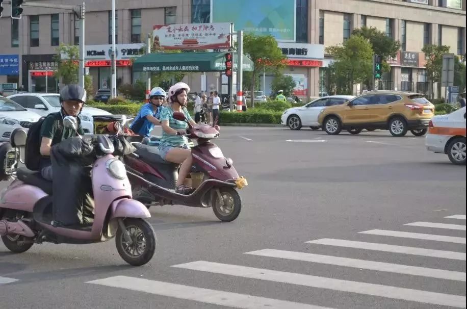 电动自行车驾乘人员佩戴安全头盔新规实施半个多月大家骑车都戴头盔了