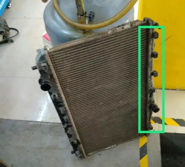 此时,师傅用高压水枪把冷凝器冲洗干净.