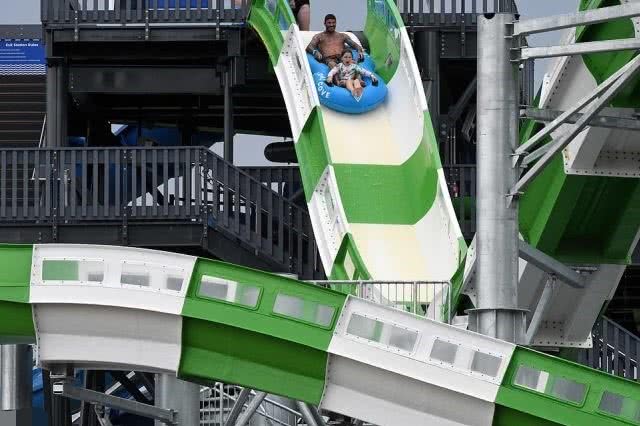 着小七在一个反重力的水上滑梯游玩,两人还跳上救生艇,顺着水槽往下走