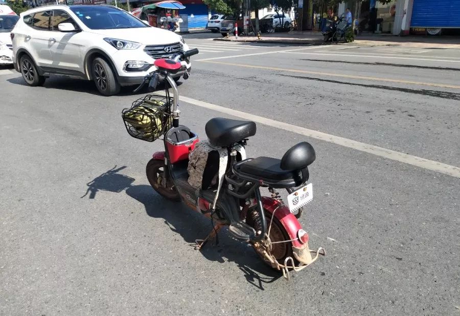 一辆白色小轿车与电动车相撞