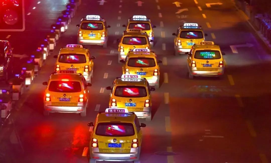 出租车的后屏集体"红旗飘飘",气宇轩昂的五星红旗和夜间灯光交相辉映