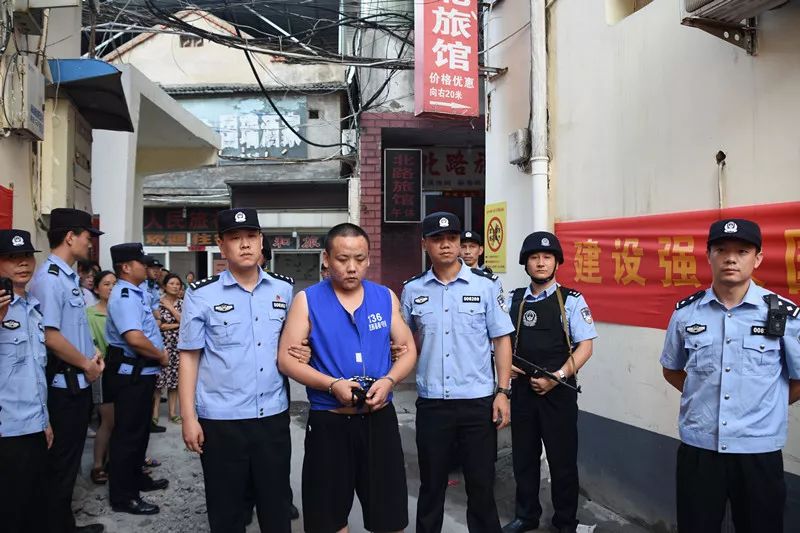 走上街头指认犯罪现场在警察的押解下几个戴黑头套的人合肥街头