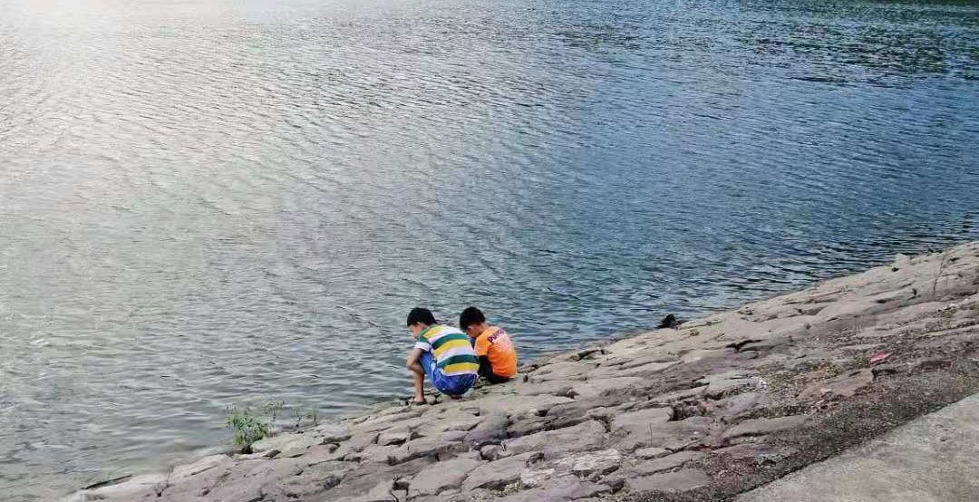 2网格员许绪团例行巡查到龙头水库的时候发现两个小孩在水库边玩水