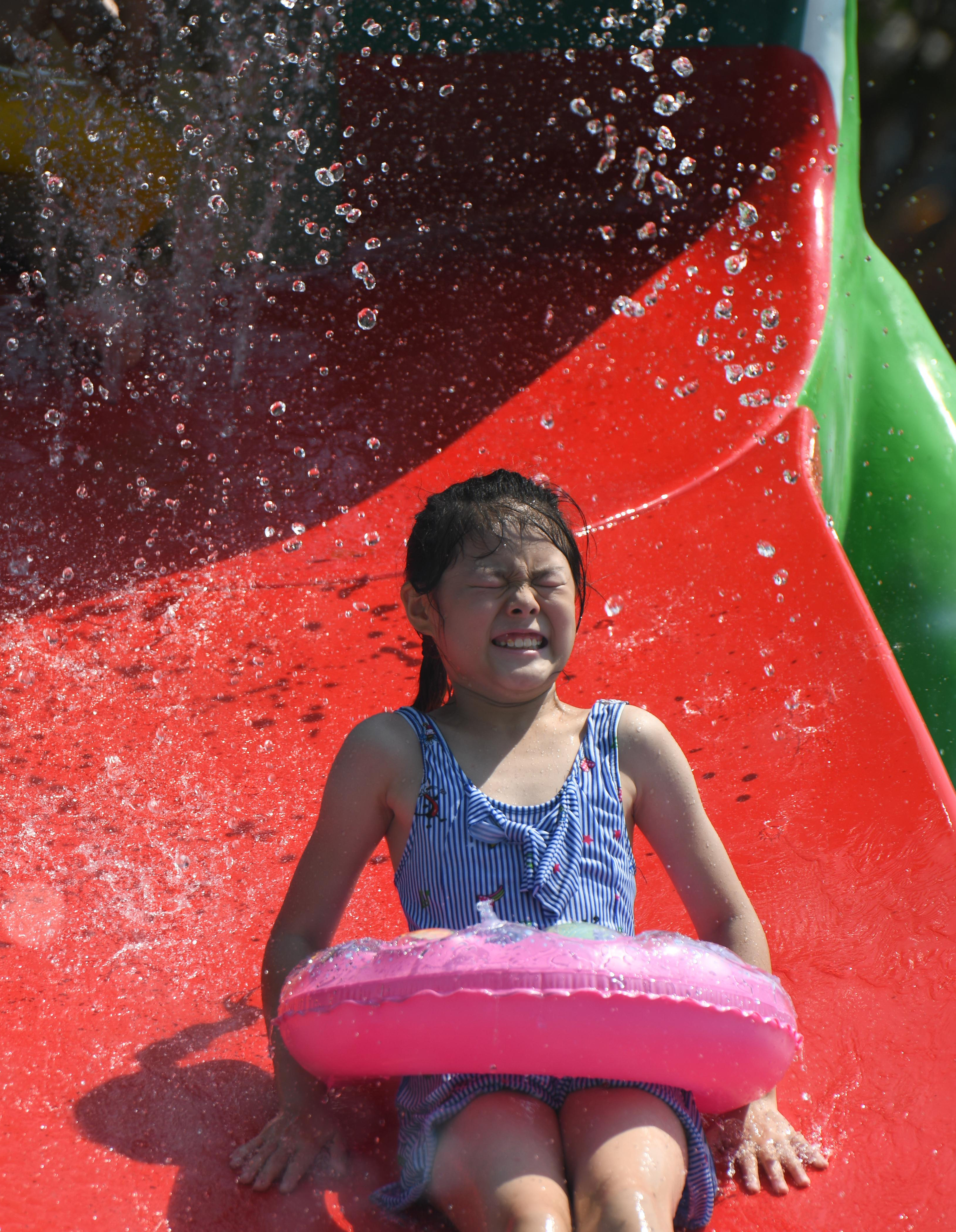 7月28日,小朋友在位于合肥的阿酋湾水上乐园戏水纳凉