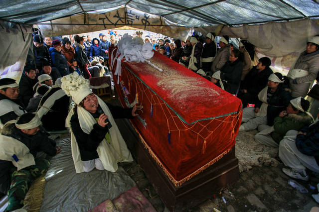 与参加葬礼的鼓乐队组成一个团体) 扮演成死者女儿的角色在棺材前(一