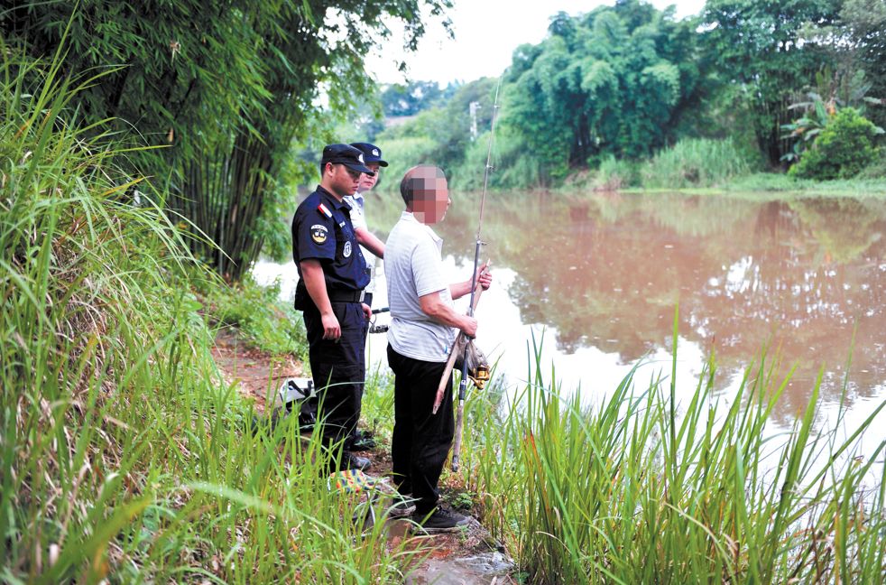 执法行动中,执法民警驱离违法垂钓人员.