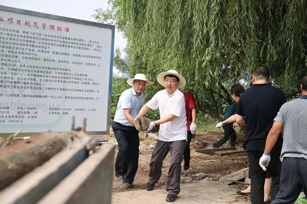 在仁和镇庄头村,高朋与党员干部群众一起清运建筑废弃物,打扫街巷道路