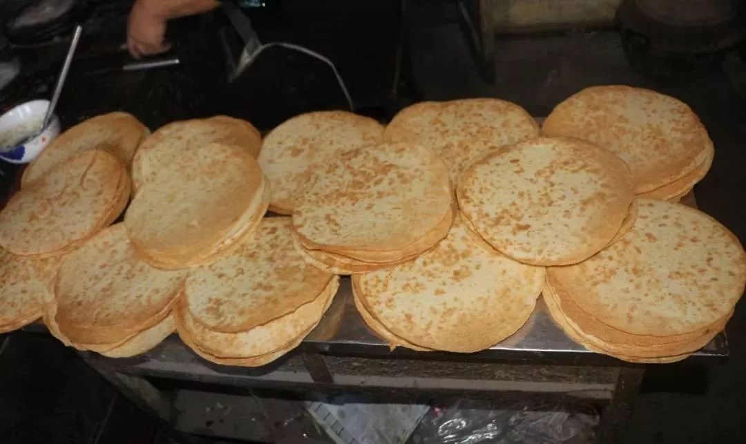 看看透不透光就知道 一块完整的压饼举起来对着阳光 焦黄适度,薄如纸