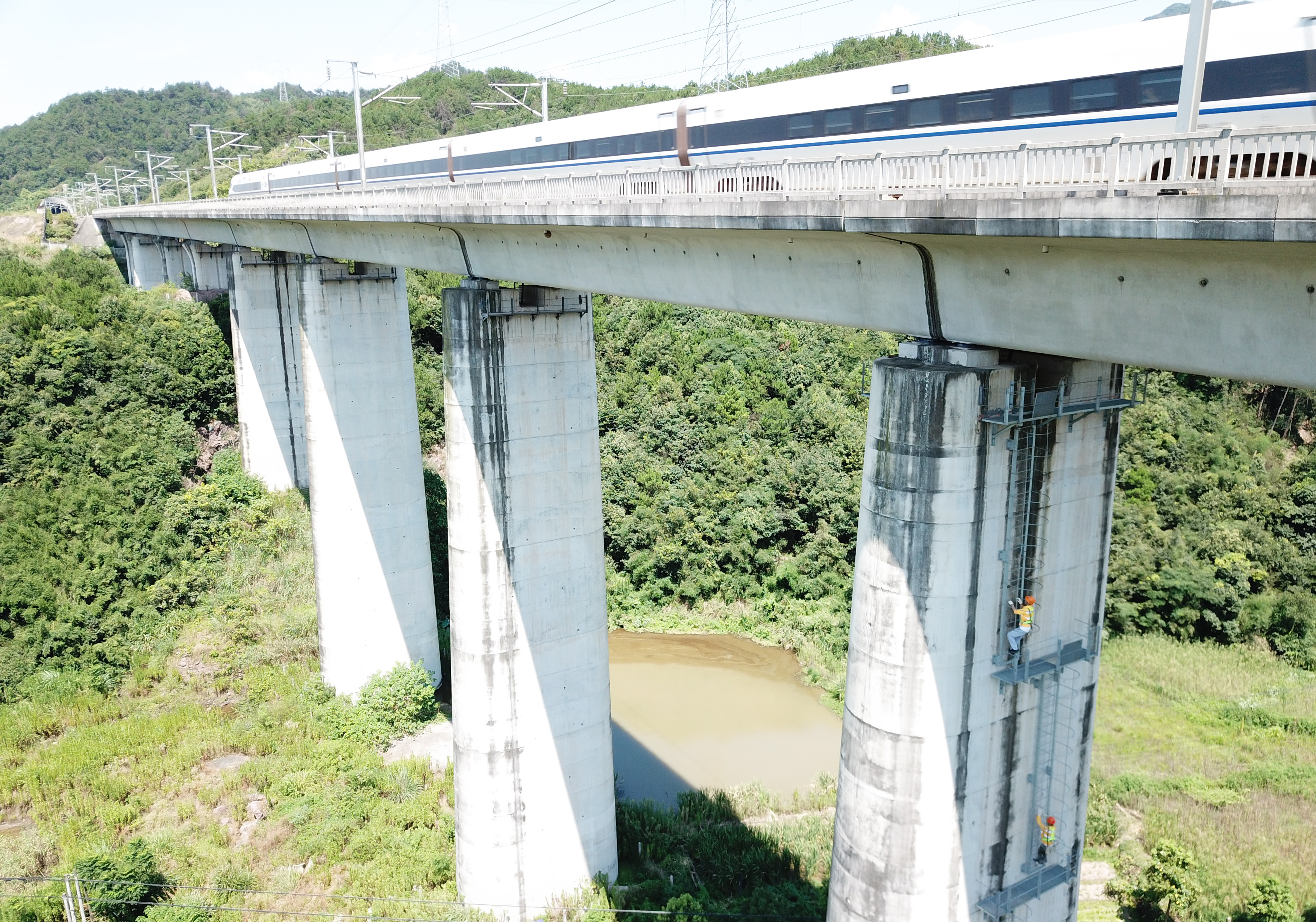 7月30日,在沪昆高铁诸暨段,桥隧工爬上几十米高的桥墩准备进行桥隧