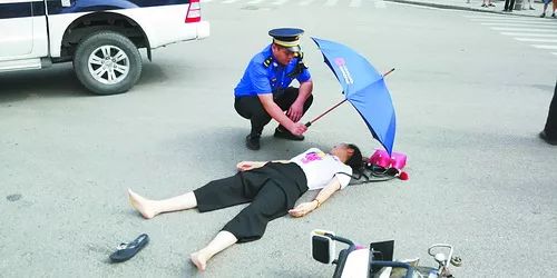 福建女子发生车祸受伤倒地起不来城管蹲下为其撑伞自己却被晒得汗流浃