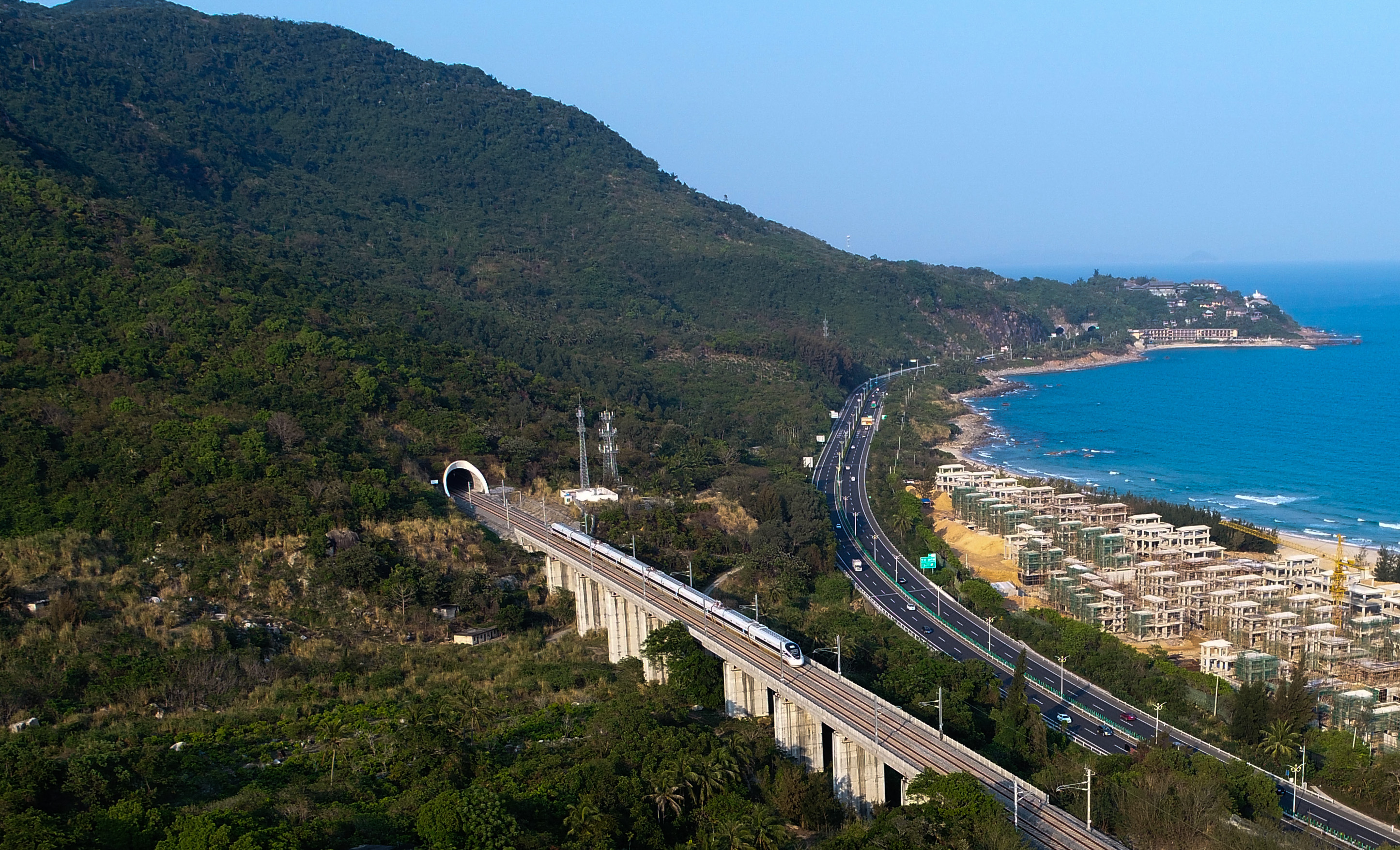 在海南环岛高铁东段陵水站附近,列车从海边驶过(2018年3月15日摄)