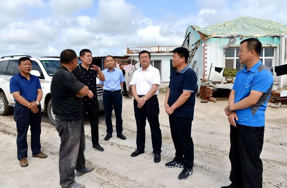 在第六作业区受灾职工王凤祥家中,李恒伟拉着他的手