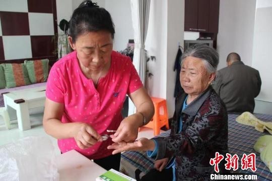 郭旭枝正在给婆婆测量血压,血糖. 柴睿凤 摄
